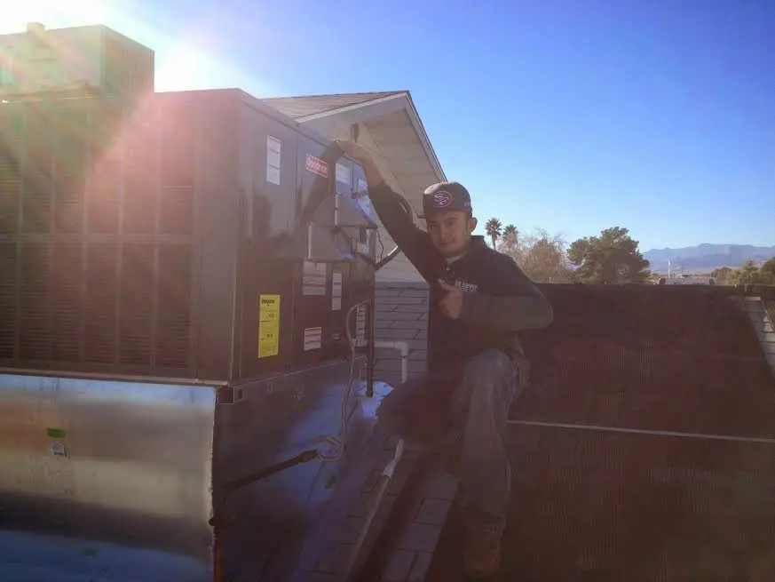 HVAC technician performing AC Tune-Up on a rooftop unit in Newmarket